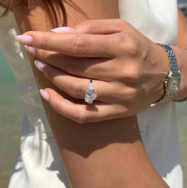 Woman wearing an elegant lab-grown diamond ring on her hand by the beach