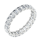 Lab-grown diamond eternity ring with emerald-cut stones set in white metal on black background