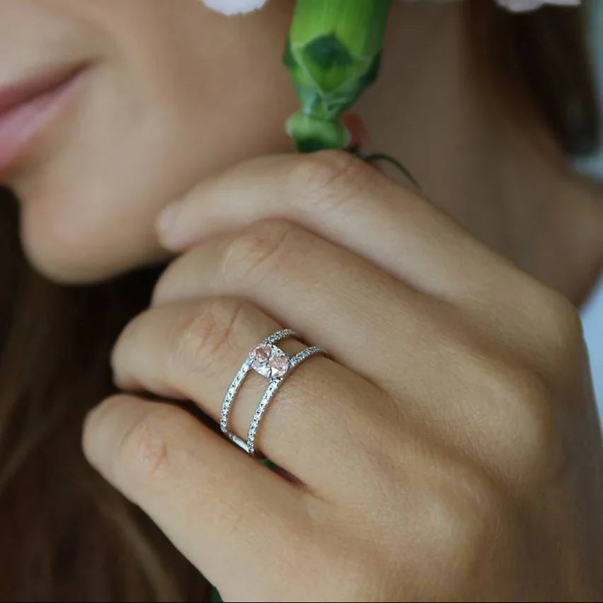 Woman wearing lab-grown diamond ring with split band, holding a green flower stem