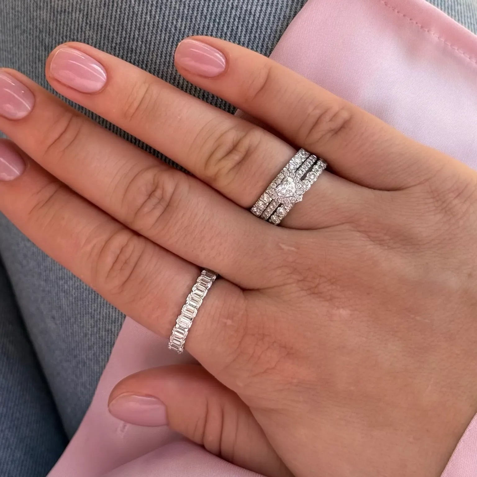 Hand with elegant lab-grown diamond rings, featuring a pear-shaped centerpiece and baguette band