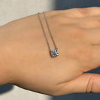 Lab-grown diamond solitaire pendant necklace on a hand in natural light