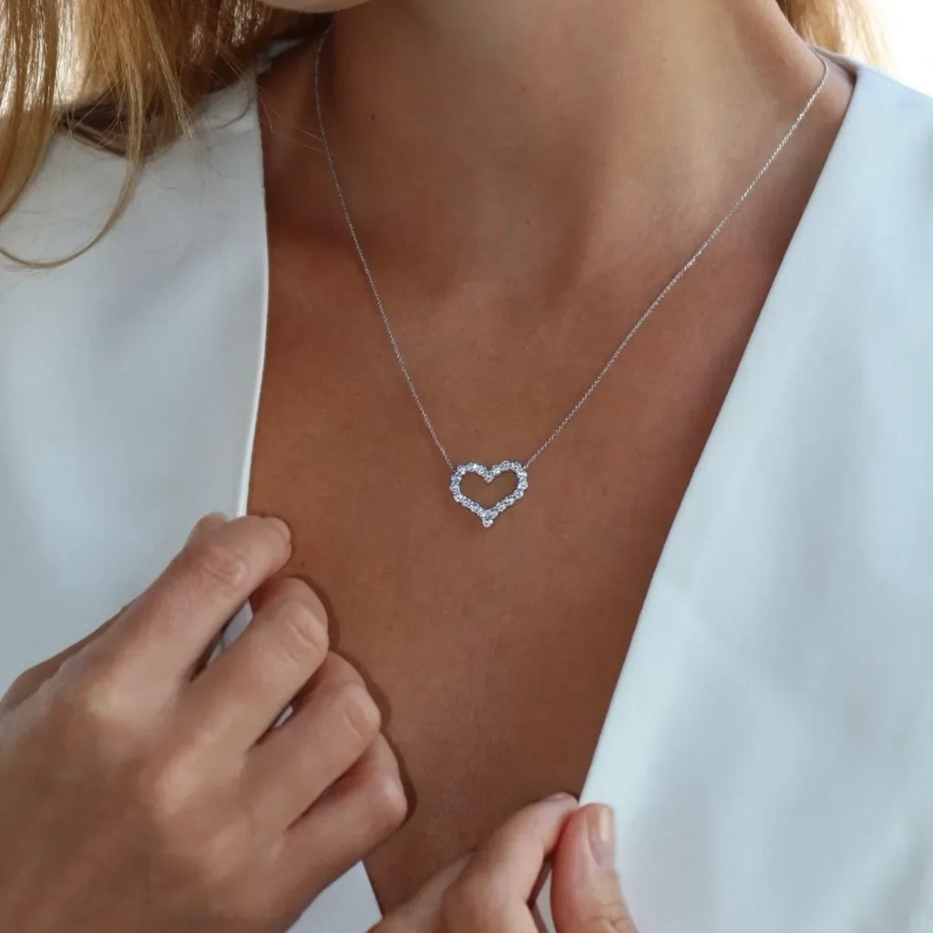 Woman wearing a heart-shaped lab-grown diamond necklace on a delicate chain