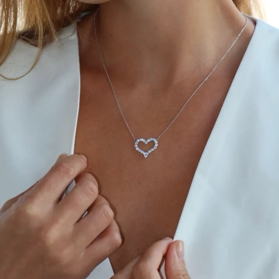 Woman wearing a heart-shaped lab-grown diamond necklace on a delicate chain