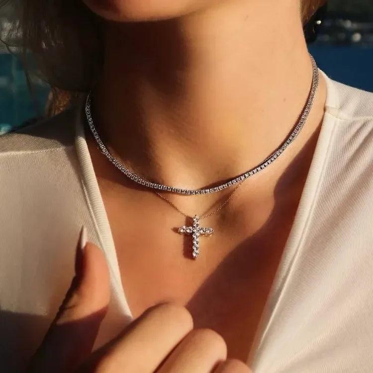 Woman wearing lab-grown diamond tennis necklace and diamond cross pendant necklace