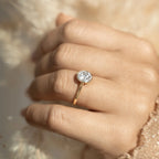 Hand wearing a gold lab-grown diamond solitaire ring with round bezel setting