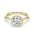 Gold ring with a round lab-grown diamond solitaire on white background
