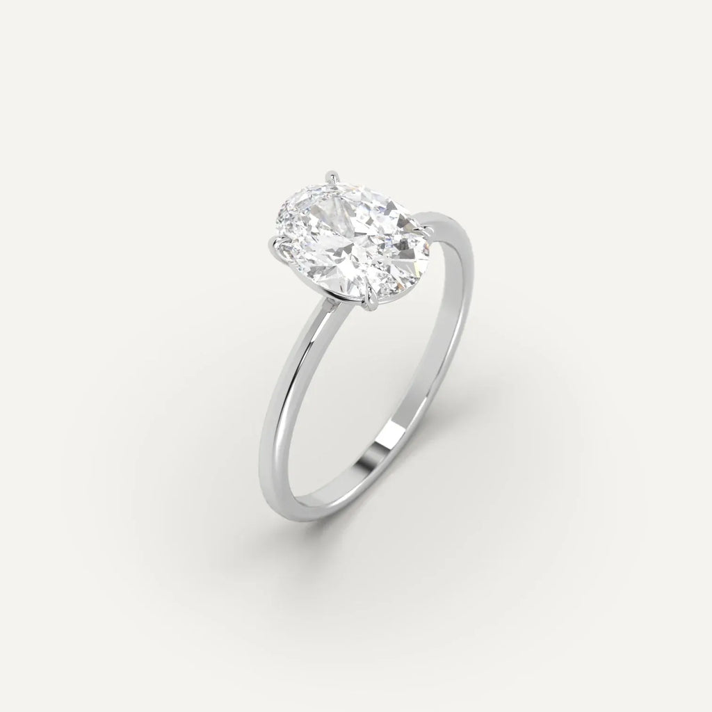 Oval lab-grown diamond solitaire ring in white gold setting on plain background