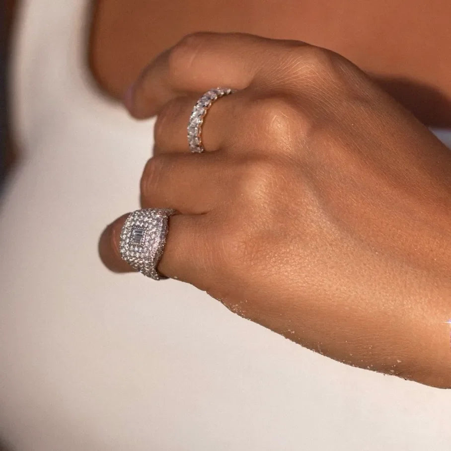 Hand wearing sparkling lab-grown diamond rings with a white background, jewelry detail