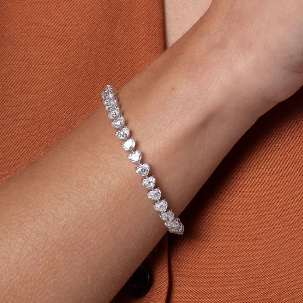 Lab-grown diamond tennis bracelet on wrist, elegant jewelry in close-up, orange blazer