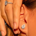 Woman wearing pear-shaped lab-grown diamond stud earring and diamond ring